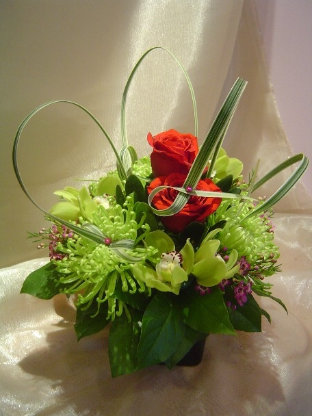 Roses, cymbidium orchids, spider mums, waxflowers, and monkey grass