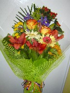 Roses, gerbera, iris, daisies, lilies, pompoms, solidago, and hypericum