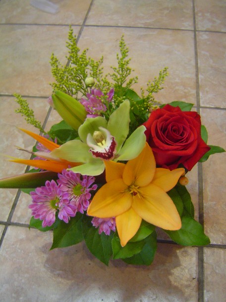 Bird of paradise, rose, cymbidium orchid, lilies, daisies, and solidago