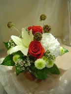 Roses, commercial mum, lily, scabiosa, pompoms, and waxflowers