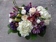 Cymbidium orchids, hydreangeas, roses, lisianthus, tinted commercial mums, alstroemeria, and pandanas leaves