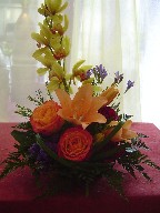 Mini cymbidium, statice, orange lillies, and circus roses