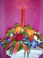 Roses, carnations, lillies, berries, orchids, pine, and Christmas decorations