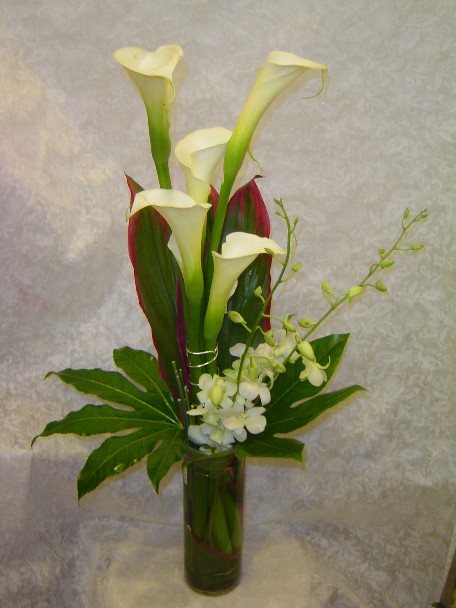 Calla lilies, dendrobium orchids, cordeline, and fatsia japonica