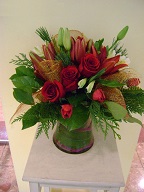 Roses, asiatic lilies, tulips, alstroemeria, cedar, pine, and Christmas decorations