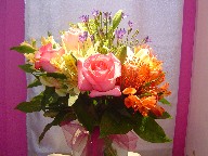 Roses, alstroemeria, protea, lillies, solidago, and brodea
