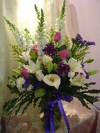 Calla lily, roses, alium, statice, snapdragon, lillies, daisies, solidago, and monkey grass